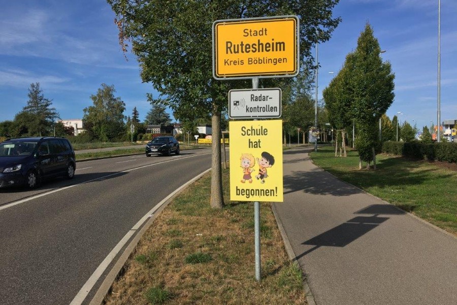 Ortsschild Rutesheim mit Zusatzschild "Schule hat begonnen"