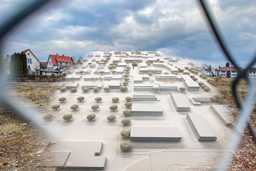 Blick durch den Drahtzaun mit Blick auf ein weißes Modell mit vielen Häusern und Bäumen Bosch-Areal und Umgebung.