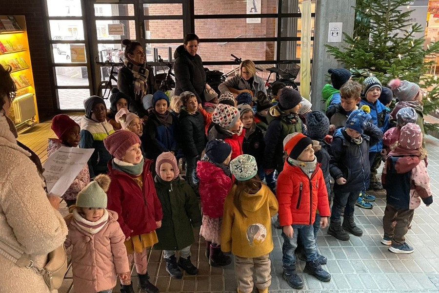 Zu sehen sind die Kindergarten-Kinder mit ihren Erzieherinnen beim Singen im Foyer des Neuen Rathauses.                    