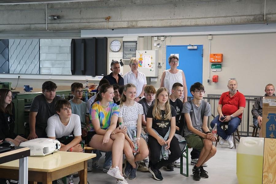 Schülerinnen und Schüler der 8. Klasse der Realschule Rutesheim sitzen auf Stühlen und hören dem Vortrag zu.        