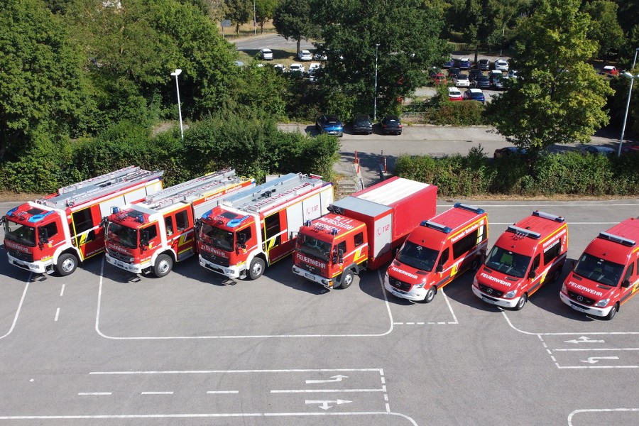 Zu sehen sind 7 rote Feuerwehrfahrzeuge, die nebeneinander geparkt wurden.rsonen von Feuerwehr, Polizei, Stadtverwaltung.                