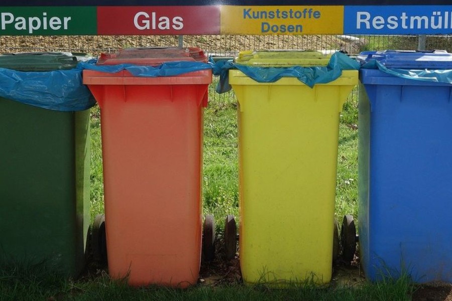 Foto mit grüner, orangener, gelber, blauer Mülltonne