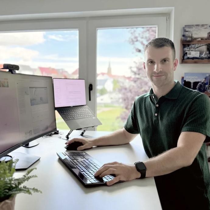 Tobias Kelm am Arbeitsplatz - hier entstehen Websites Tobias Kelm sitzt an seinem Schreibtisch und arbeitet am Laptop.