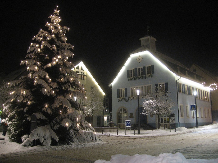 Zu sehen ist das alte Rathaus im Winter mit einem schneebedeckten Christbaum
