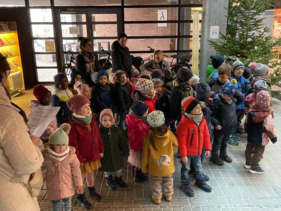 Zu sehen sind die Kindergarten-Kinder mit ihren Erzieherinnen beim Singen im Foyer des Neuen Rathauses.                    