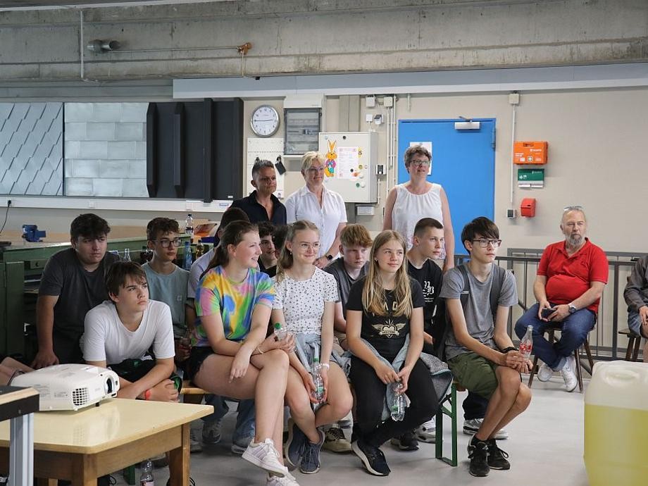 Schülerinnen und Schüler der 8. Klasse der Realschule Rutesheim sitzen auf Stühlen und hören dem Vortrag zu.        