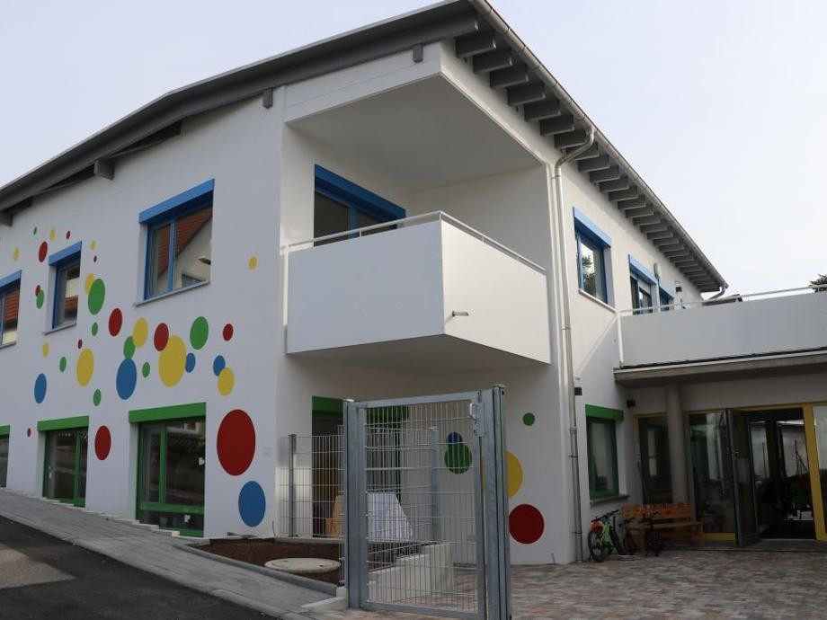 Blick auf das neue weiße, mit bunten Punkten bemalten, Gebäude des Kindergartens Perouse.         