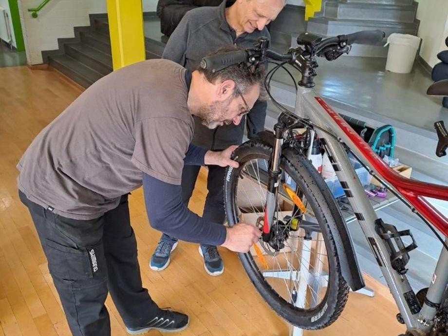 Dirk Grimm und Günter Stiefel schrauben an einem Fahrrad.