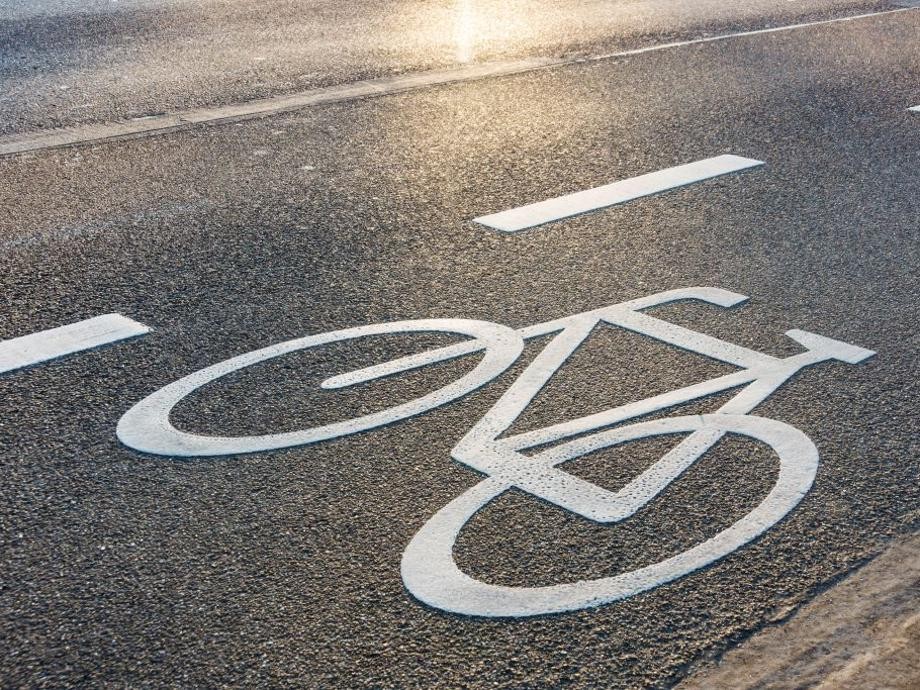 Zu sehen ist eine Fahrspur mit weiß eingezeichneten Linien und einem weiß eingezeichneten Fahrrad.