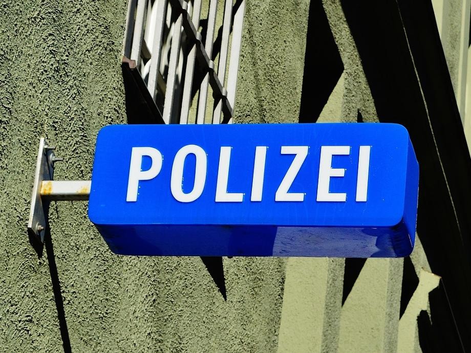 Polizei Ein an eine Hauswand montiertes blaues Schild mit der weißen Aufschrift Polizei.