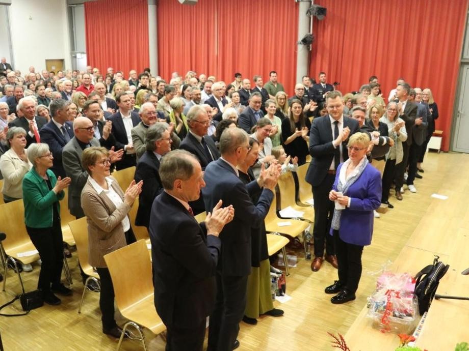 Verabschiedung BMin Widmaier Viele Personen in der voll besetzten Aula applaudieren mit stehenden Ovationen Bürgermeisterin Susanne Widmaier.