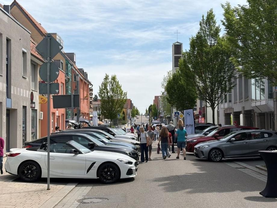 Rutesheimer Autoschau 2026 Blick in die Leonberger Straße mit rechts und links geparkten Fahrzeugen, durch die viele Besucherinnen und Besucher schlendern.