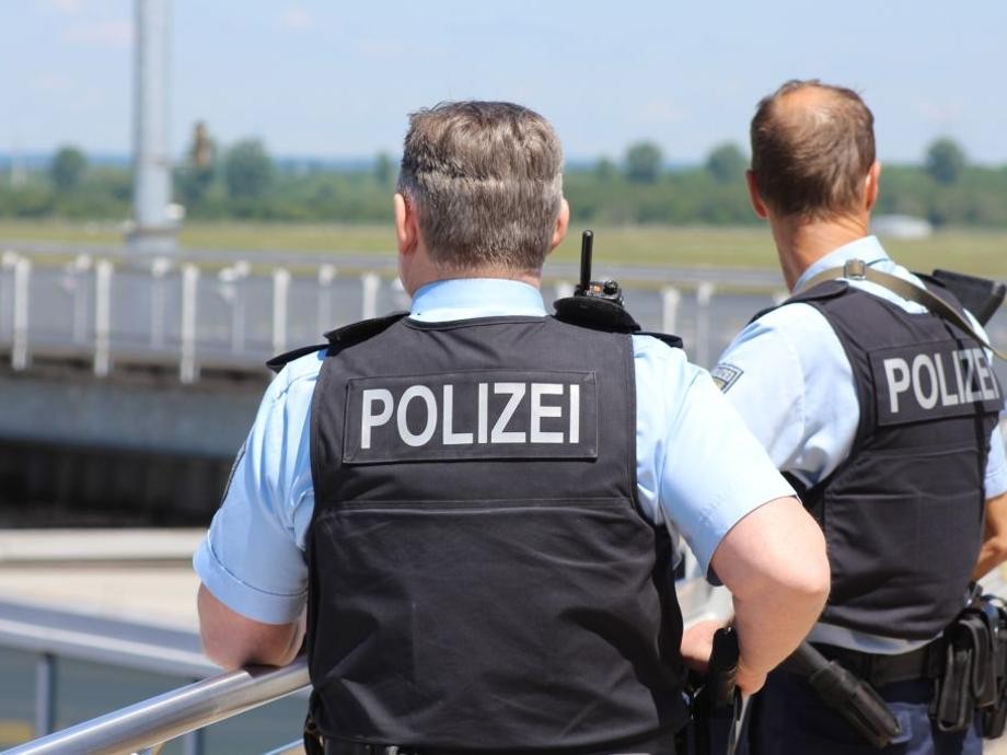 Polizei_pixabay Zwei Polizisten von hinten, auf deren Westen in Großbuchstaben Polizei steht.