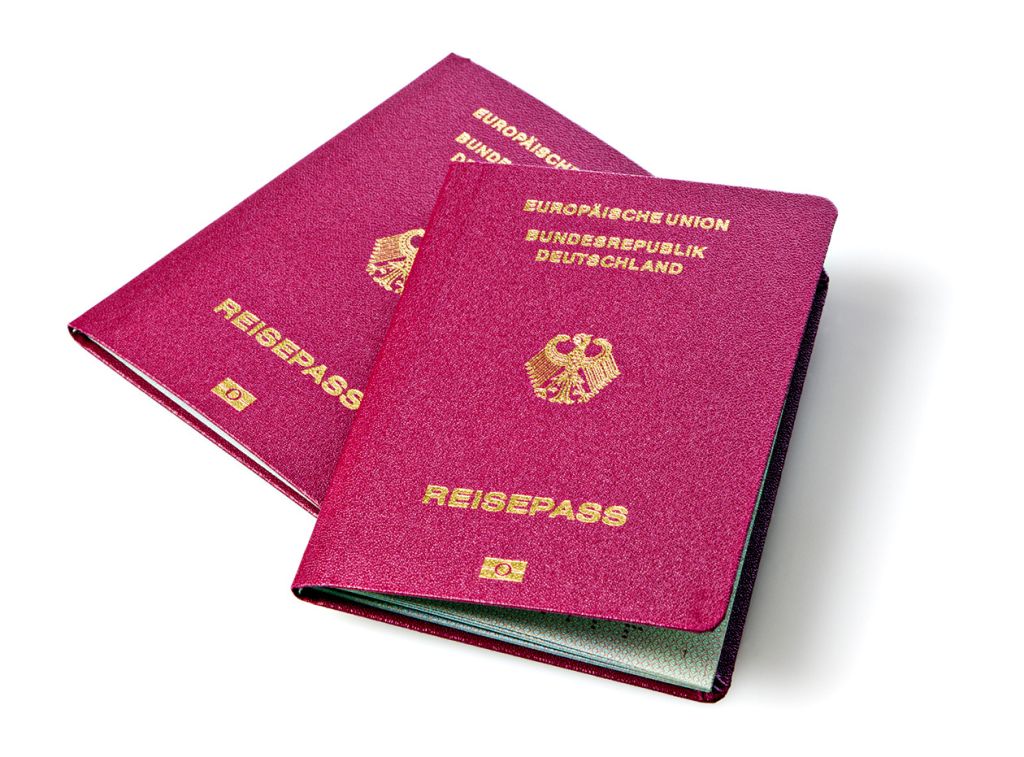Zwei rote deutsche Reisepässe mit goldenem Bundesadler und der Aufschrift Europäische Union Bundesrepublik Deutschland Reisepass.            