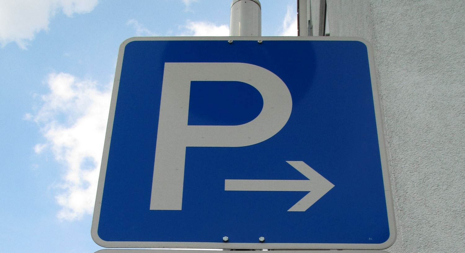Blaues Verkehrsschild mit weißem P in Großbuchstaben und einem weißen Pfeil nach rechts.