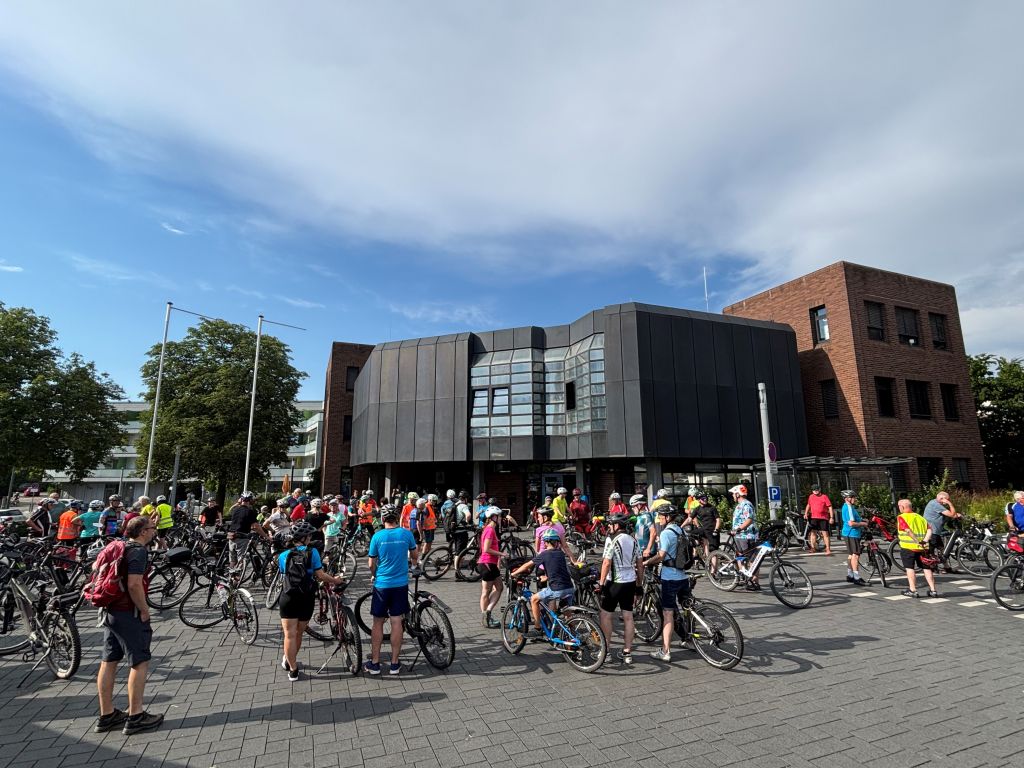 Viele Radfahrerinnen und Radfahrer stehen mit ihren Rädern vor dem Neuen Rathaus.