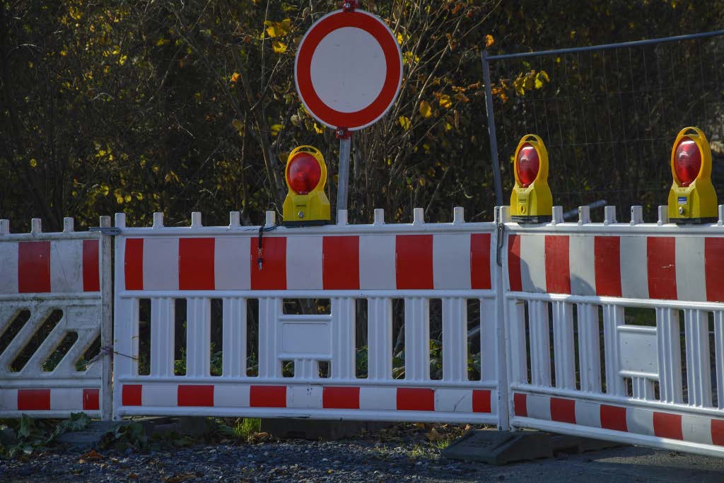 Baustellenabsperrung mit einer Warnbake mit Beleuchtung und einem Schild Durchfahrt verboten.